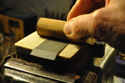 rub the block lengthwise across a strip of abrasive paper